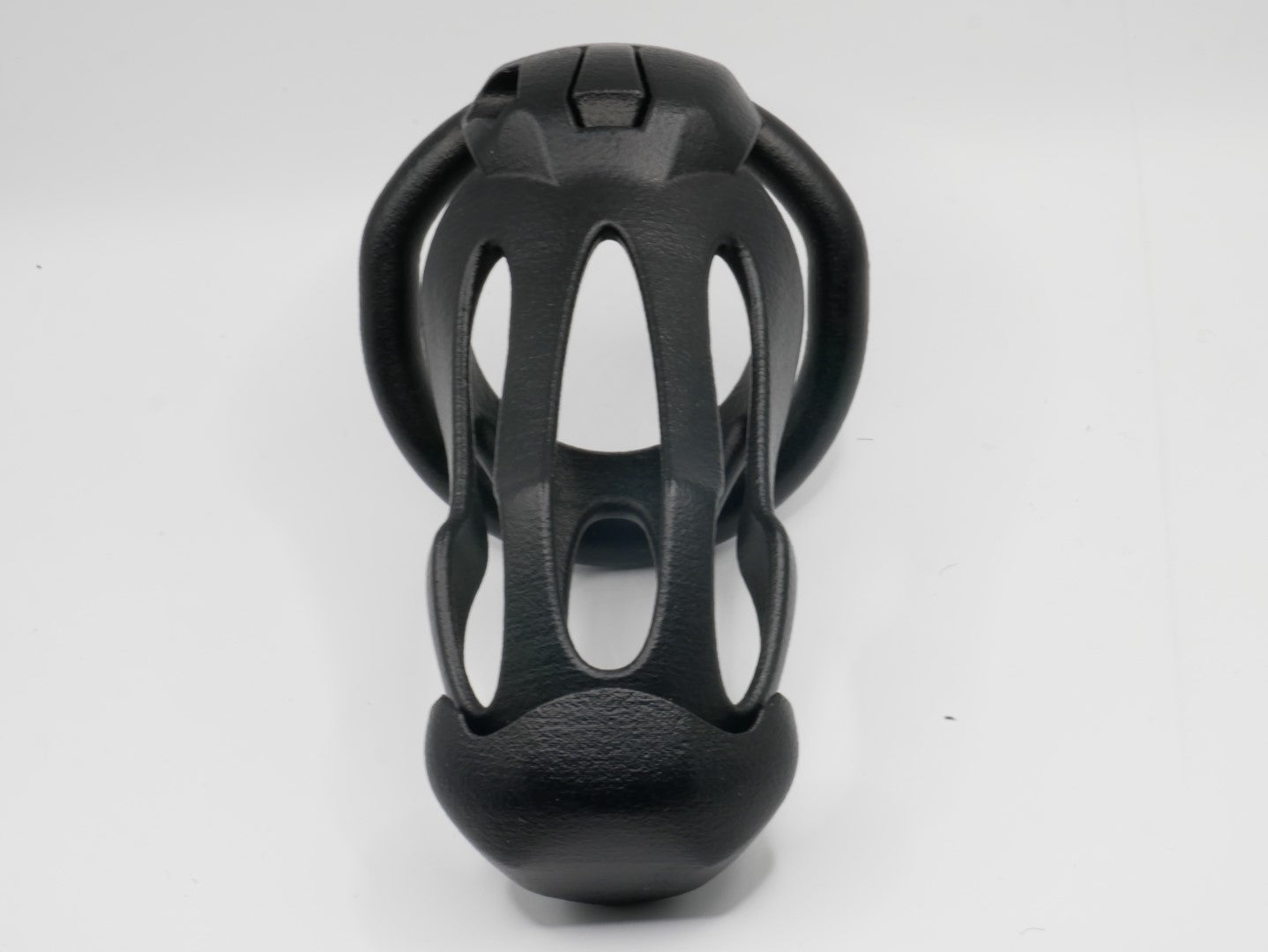 A black chastity cage with an open design, featuring a front cap and a lockable mechanism.