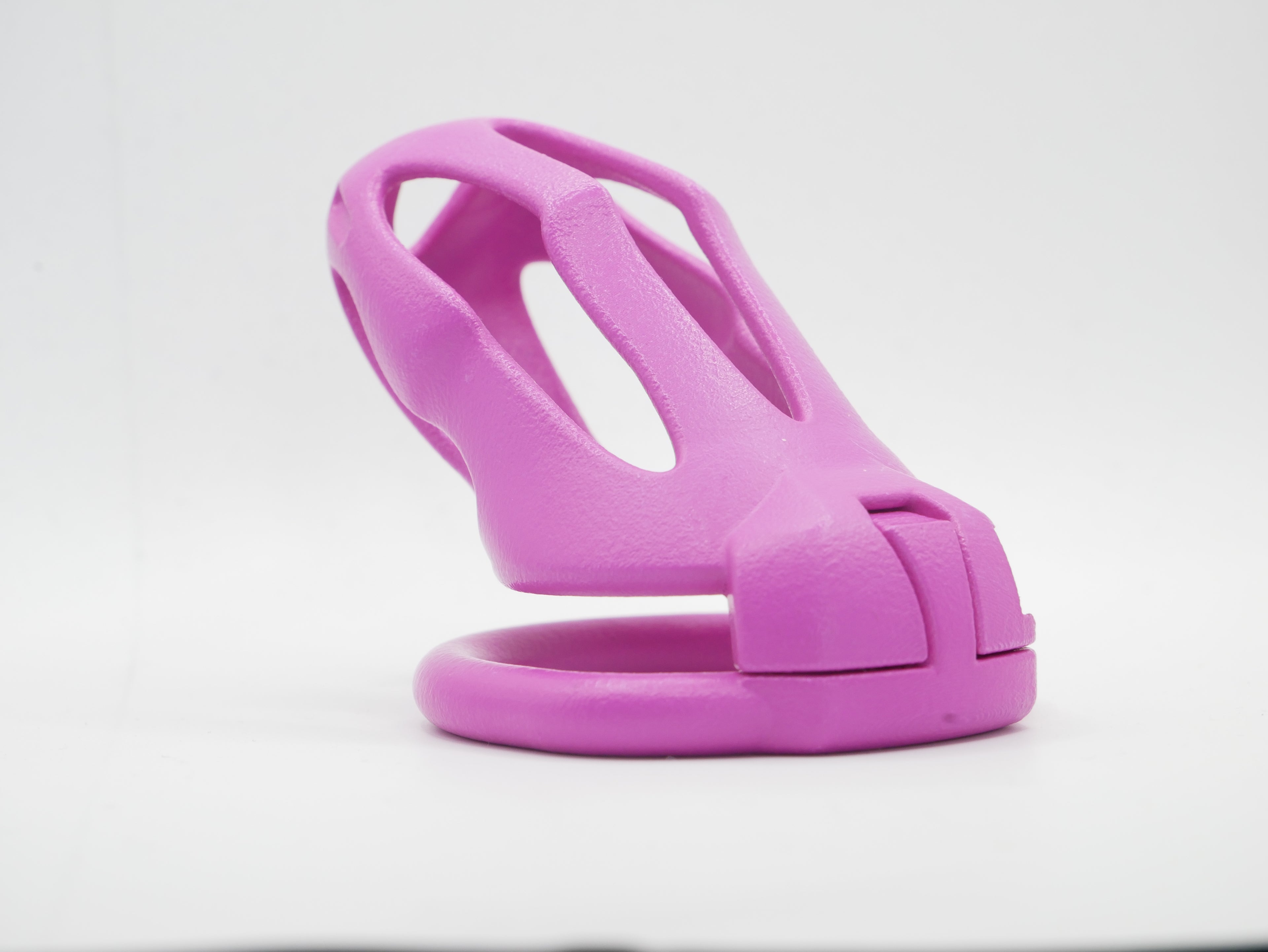 A pink chastity cage with an open design, featuring a front cap and a lockable mechanism.