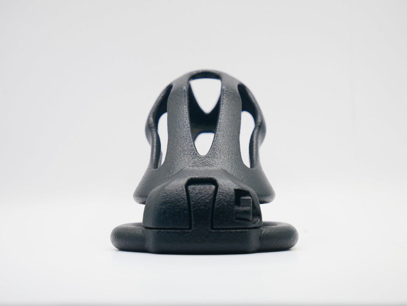 smooth black chastity cage, with a slim integrated locking mechanism on a white background